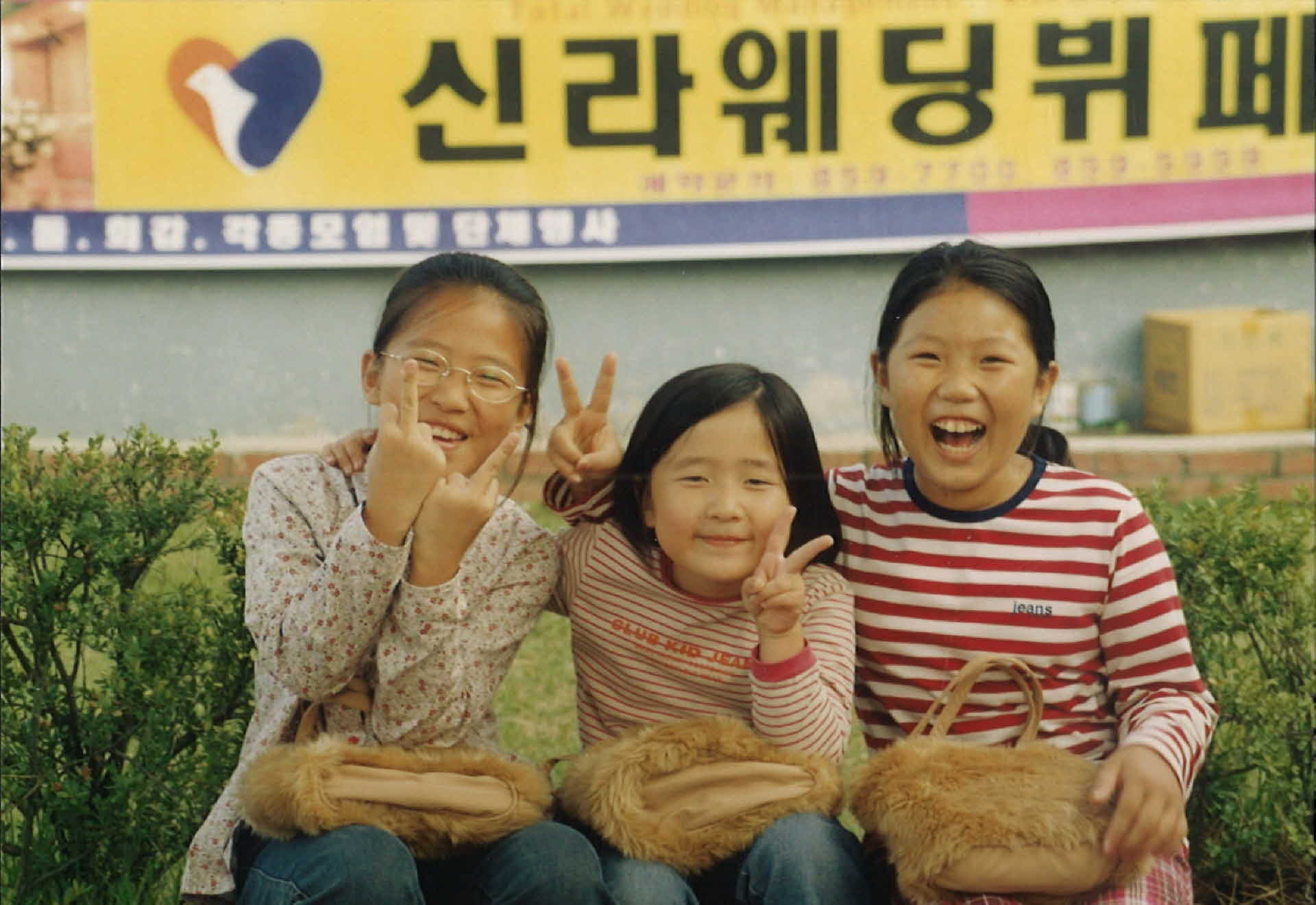 신라웨딩뷔페현수막 앞 여자어린이 3명